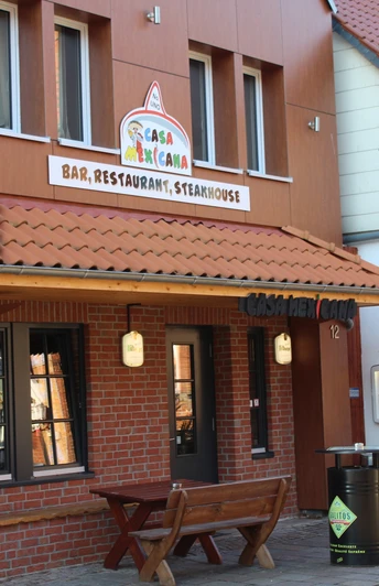 Mexikanisches Restaurant mit Holzfassade, rotem Ziegeldach, Holzbänken und Terrasse in einem Fachwerkgebäude.Mexican restaurant with wooden façade, red tiled roof, wooden benches and terrace in a half-timbered building.Mexicansk restaurant med træfacade, rødt tegltag, træbænke og terrasse i en bindingsværksbygning.Mexicaans restaurant met houten gevel, rood pannendak, houten banken en terras in een vakwerkgebouw.
