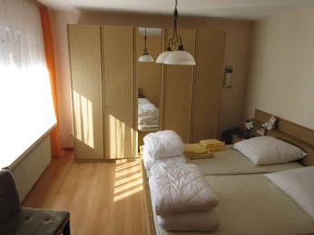 Ferienwohnung Bade Helles Schlafzimmer in Ferienwohnung mit zwei Einzelbetten, Bettwäsche, Schrank und Tageslicht.