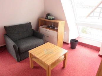 Eine stilvolle Sitzecke in einem hellen Zimmer mit rotem Teppich und Fenster.A stylish seating area in a bright room with a red carpet and window.Et stilfuldt siddeområde i et lyst rum med rødt tæppe og vindue.Een stijlvolle zithoek in een lichte kamer met rood tapijt en raam.