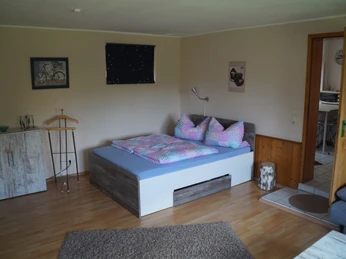 Ferienwohnung Wehrmann Ferienwohnung mit Doppelbett, bunter Bettwäsche und Holzfußboden; Zugang zu einem gefliesten Badezimmer.Apartment with double bed, colorful bedding and wooden floor; access to a tiled bathroom.Ferielejlighed med dobbeltseng, farverigt sengelinned og trægulv; adgang til flisebadeværelse.Vakantiewoning met tweepersoonsbed, kleurrijk beddengoed en houten vloer; toegang tot een betegelde badkamer.