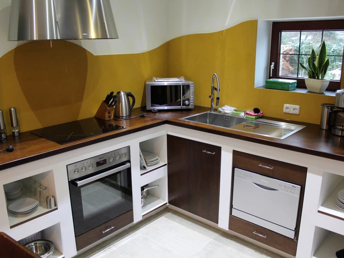 Eine moderne Küche mit Holzarbeitsplatte, ausgestattet mit Herd, Mikrowelle und Spülmaschine.A modern kitchen with wooden worktop, equipped with stove, microwave and dishwasher.Et moderne køkken med træbordplade, udstyret med komfur, mikroovn og opvaskemaskine.Een moderne keuken met houten werkblad, uitgerust met een fornuis, magnetron en vaatwasser.
