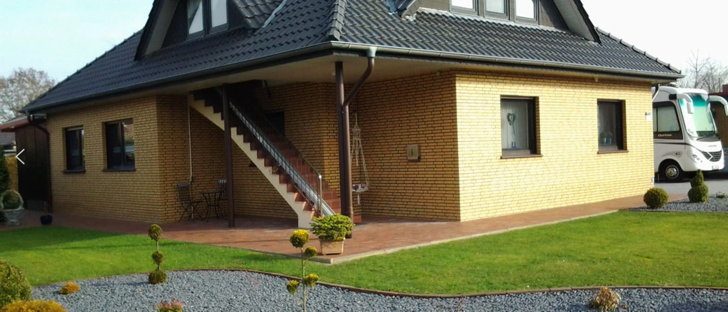 wohnung-am-moor-bockhorst Backsteinhaus mit gepflegtem Garten, Außentreppe und überdachter Terrasse in ruhiger Wohnlage