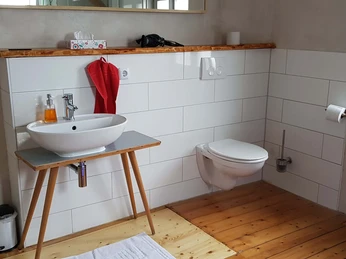 Badezimmer mit Waschbecken auf altem Tisch und Toilette