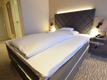 villa-huxori-einzelzimmer-5 Großes Bett mit Beleuchtung und Haustelefon