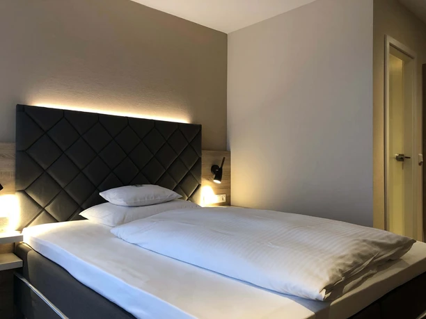 Großes Bett mit stimmungsvoller Beleuchtung