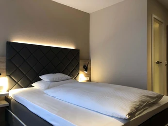 villa-huxori-einzelzimmer-1 Großes Bett mit stimmungsvoller Beleuchtung