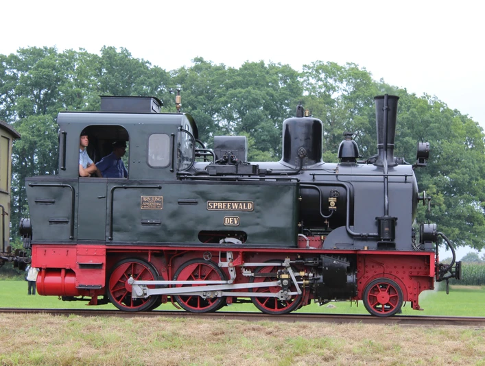 Museums-Eisenbahn Bruchhausen-Vilsen Historische Dampflok namens "Spreewald" auf einer grünen Wiese mit Bäumen im Hintergrund, seitlich fotografiert.Historic steam locomotive named "Spreewald" on a green meadow with trees in the background, photographed from the side.Historisk damplokomotiv ved navn "Spreewald" på en grøn eng med træer i baggrunden, fotograferet fra siden.Historische stoomlocomotief met de naam "Spreewald" op een groene weide met bomen op de achtergrond, gefotografeerd vanaf de zijkant.