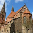 Stiftskirche Bücken: Historische Kirche aus rotem Backstein mit markanten Türmen unter blauem Himmel.