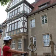 Altes Amtsgericht Zwei Radfahrerinnen mit Helmen betrachten moderne Bronzefiguren vor einem Fachwerkgebäude.Two cyclists with helmets look at modern bronze figures in front of a half-timbered building.To cyklister med hjelm kigger på moderne bronzefigurer foran en bindingsværksbygning.Twee fietsers met helmen kijken naar moderne bronzen figuren voor een vakwerkgebouw.