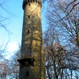 Wilhelmsturm Der Wilhelmsturm erhebt sich majestätisch aus einem bewaldeten Umfeld und strahlt in der Sonne.