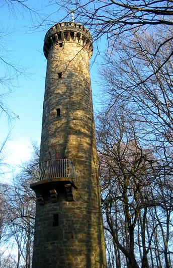 Wilhelmsturm Der Wilhelmsturm erhebt sich majestätisch aus einem bewaldeten Umfeld und strahlt in der Sonne.