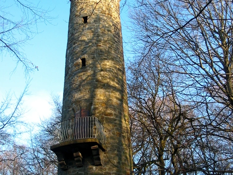 Wilhelmsturm Der Wilhelmsturm erhebt sich majestätisch aus einem bewaldeten Umfeld und strahlt in der Sonne.