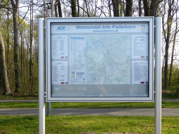 Informations-Schaukasten am Stellplatz Karte und Informationen zu Wohnmobilstellplätzen in einem Schaukasten vor einem Waldhintergrund.