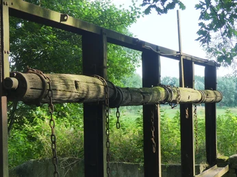 Altes Lippewehr Historisches hölzernes Wehr umgeben von Bäumen, nutzt Ketten und Metall für Wasserregulierung.