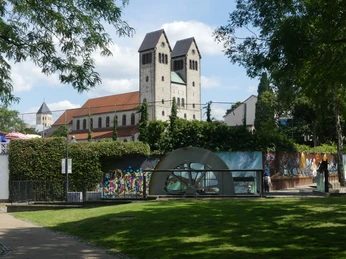 Funktionsmodell und Abdinghofkirche Die Abdinghofkirche mit einem modernen Funktionsmodell im Vordergrund, umgeben von Graffitikunst.