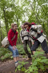 Wandergruppe im Wald Eine fröhliche Wandergruppe genießt einen Spaziergang durch einen grün bewaldeten Pfad.