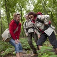 Wandergruppe im Wald Eine fröhliche Wandergruppe genießt einen Spaziergang durch einen grün bewaldeten Pfad.