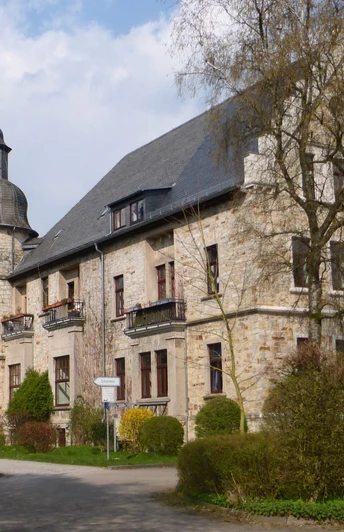 Schloss Hamborn bei Borchen Schloss Hamborn bei blühenden Bäumen vor bewölktem Himmel, verbindet historische Architektur mit Natur.