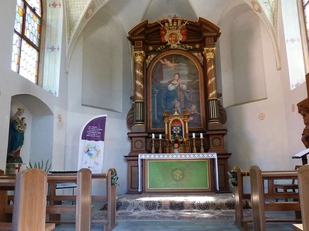 Innenraum der Kluskapelle St. Lucia Altar der Kluskapelle St. Lucia mit reich verzierten Holzarbeiten, Marienbild und bunten Kirchenfenstern.