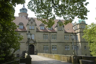Wasserschloss Ulenburg Wasserschloss Ulenburg umgeben von Bäumen, mit Brücke zum Eingang und markanten Türmen.