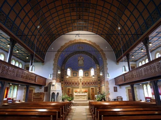 Christuskirche Obernbeck Innenansicht der Christuskirche Obernbeck mit Holzbänken, verziertem Altarraum und kunstvollem Gewölbe.