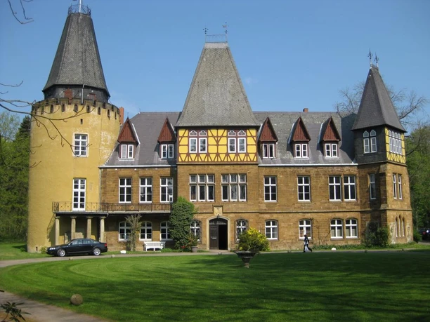 Schloss Hollwinkel im Mühlenkreis Schloss Hollwinkel im Mühlenkreis mit zwei markanten Türmen und Fachwerkfassade in grüner Umgebung.