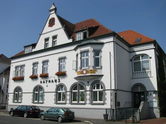 Das Rathaus von Pr. Oldendorf, ein prächtiges, historisches Gebäude mit verzierten Fenstern und Blumenkästen.