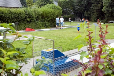 Minigolfanlage Pr. Oldendorf Minigolfplatz mit Rasenbahnen, Spielern und gemütlicher Gartenatmosphäre im Grünen umgeben.