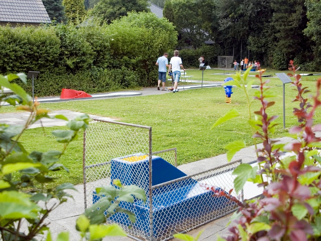 Minigolfanlage Pr. Oldendorf Minigolfplatz mit Rasenbahnen, Spielern und gemütlicher Gartenatmosphäre im Grünen umgeben.