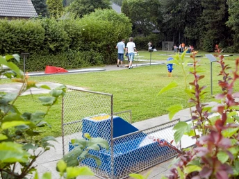 Minigolfanlage Pr. Oldendorf Minigolfplatz mit Rasenbahnen, Spielern und gemütlicher Gartenatmosphäre im Grünen umgeben.