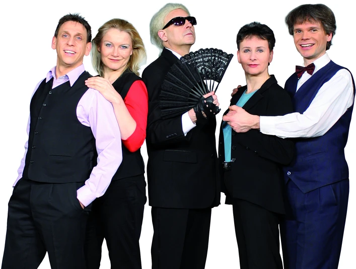 Team des Kabarett-Theaters Leipziger Funzel Fünf Personen posieren in schwarzer Theaterkleidung vor weißem Hintergrund.Five people pose in black theater clothes in front of a white background.Pět osob v černém divadelním oblečení pózuje před bílým pozadím.Pięć osób pozuje w czarnych strojach teatralnych na białym tle.Vijf mensen poseren in zwarte theaterkleding voor een witte achtergrond.Cinque persone posano in abiti teatrali neri davanti a uno sfondo bianco.