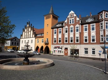 Altes Rathaus Lübbecke Brunnenplatz mit altem Rathaus in Lübbecke, umgeben von historischer Architektur und blauen Himmel.
