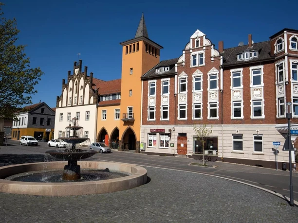 Altes Rathaus Lübbecke Brunnenplatz mit altem Rathaus in Lübbecke, umgeben von historischer Architektur und blauen Himmel.