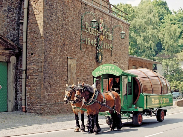 Barres Brauwelt Historische Brauerei mit eindrucksvoller Fassade; Pferdekutsche mit grüner Aufschrift „Barre's“.