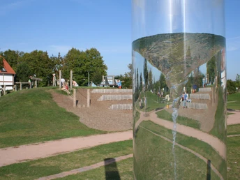 Großer Wasserspielplatz in Bruchhausen-Vilsen mit Röhrenstrudel im Vordergrund, Kinder spielen.