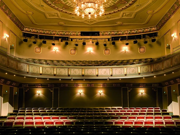Interior view of the König Albert Theater Bad Elster, with magnificent chandelier and elegant rows of seats.