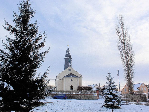 Die Röthenbacher Kirche im Winter Eine schneebedeckte Kirche neben schneebedeckten Bäumen im Winter.