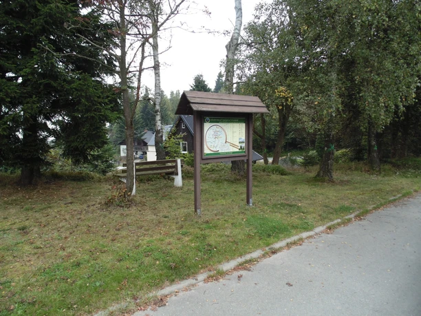 Wanderparkplatz am Eulenberg Wanderparkplatz am Eulenberg mit Infotafel und Sitzbank, umgeben von Bäumen am Waldrand.
