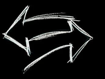 image Weiße Kreidepfeile zeigen in entgegengesetzte Richtungen auf schwarzem Hintergrund.White chalk arrows point in opposite directions on a black background.Bílé křídové šipky na černém pozadí ukazují do opačných směrů.Białe kredowe strzałki wskazują przeciwne kierunki na czarnym tle.Witte krijtpijlen wijzen in tegengestelde richtingen op een zwarte achtergrond.Frecce di gesso bianco puntano in direzioni opposte su uno sfondo nero.