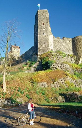 Burg Stolpen Mächtige Burg Stolpen auf felsiger Anhöhe, umgeben von herbstlichem Laub und Radfahrer im Vordergrund.Mighty Stolpen Castle on a rocky hill, surrounded by autumn foliage and cyclists in the foreground.Mohutný hrad Stolpen na skalnatém kopci, obklopený podzimním listím a cyklisty v popředí.Potężny zamek Stolpen na skalistym wzgórzu, otoczony jesiennymi liśćmi i rowerzystami na pierwszym planie.Het machtige kasteel Stolpen op een rotsachtige heuvel, omringd door herfstbladeren en fietsers op de voorgrond.Il possente castello di Stolpen su una collina rocciosa, circondato da fogliame autunnale e ciclisti in primo piano.