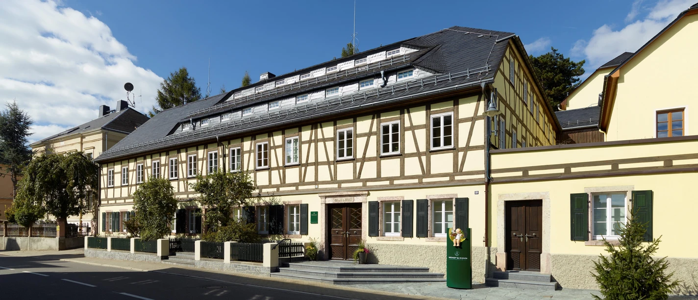 Wendt & Kühn-Welt hinter historischer Fachwerkfassade_Juliane Mostertz.jpg Ein Fachwerkgebäude mit modernem Eingang und einem Zylinder-Lichtobjekt davor.