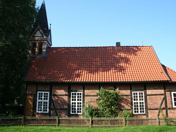 Fachwerkkapelle Anderten Historisches Fachwerkgebäude mit Glockenturm, roten Dachziegeln und weißen Sprossenfenstern.