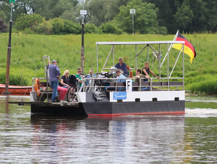 Weserfähre Gentsiet Hagen-Grinden - Ahsen-Oetzen Weserfähre transportiert Personen und Fahrräder über einen ruhigen Fluss vor grüner Landschaft.