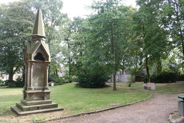Steinernes Langensalza-Denkmal im Grünen, umgeben von Bäumen und einem gepflegten Weg.
