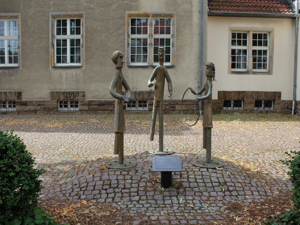 Amtsgericht Petershagen Drei bronzene Skulpturen stehen auf einem gepflasterten Platz vor dem Amtsgericht Petershagen.