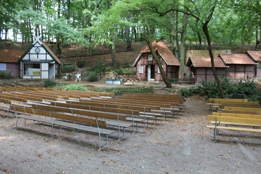 Freilichtbühne Marklohe Freilichtbühne Marklohe mit Holzbänken vor rustikalen Bühnenhäusern im Wald, herbstlich umrahmt.
