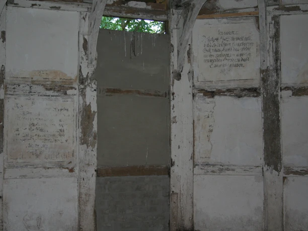 Wandmalereien Kloster Schinna Wall paintings in Schinna Monastery; faded lettering on aged white-grey wooden walls.
