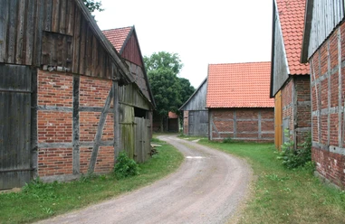 Scheunenviertel Schlüsselburg Eine gepflasterte Straße schlängelt sich durch ein historisches Ensemble aus Fachwerkscheunen.