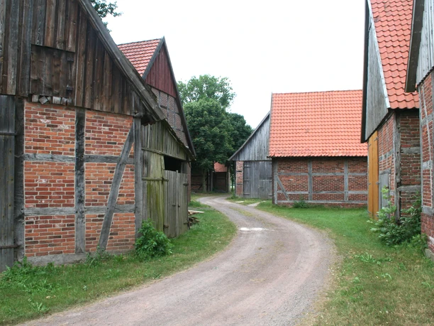 Scheunenviertel Schlüsselburg Eine gepflasterte Straße schlängelt sich durch ein historisches Ensemble aus Fachwerkscheunen.