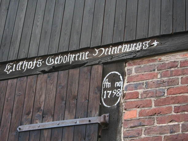 Scheunenviertel Schlüsselburg Holzscheunentor mit schwarz gestrichenen Brettern und handgemalter Inschrift "1798" in weißer Farbe.